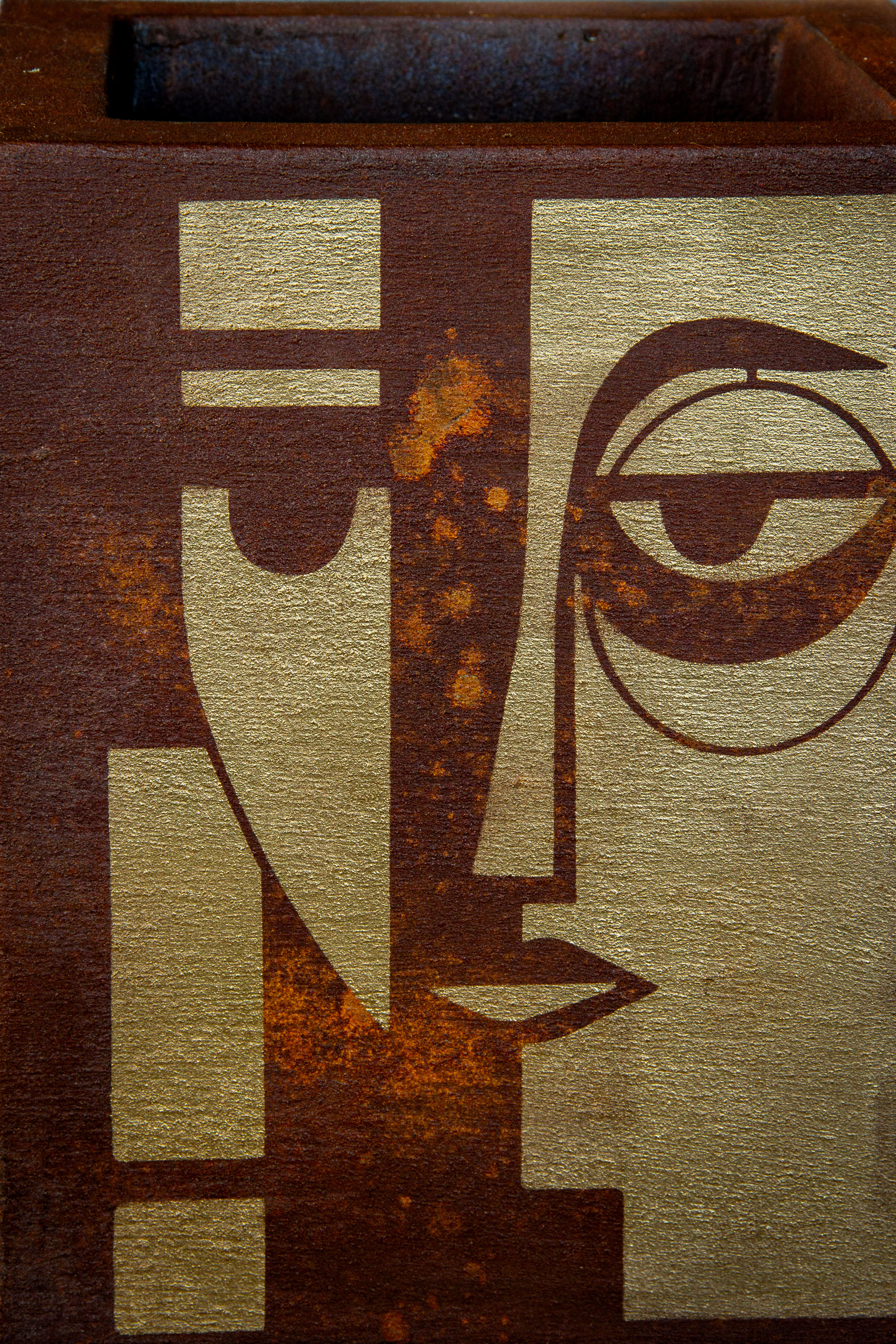 Kwadratowa osłonka loft z efektem kortenu i złotym geometrycznym wzorem twarzy, ręcznie wykonana i malowana